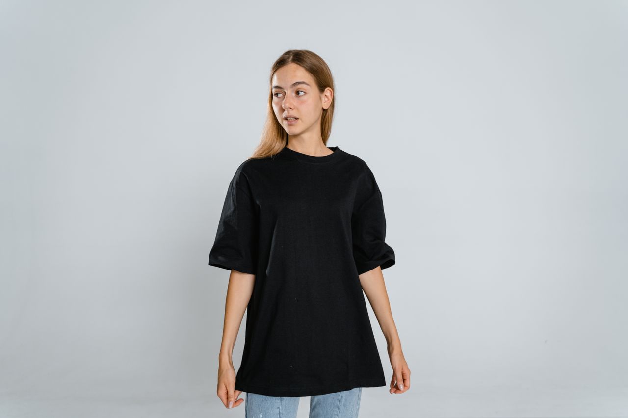 young woman in a black t shirt looking sideways in a studio setting