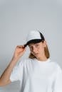Woman in White Crew Neck T-shirt Wearing White Cap