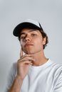 Man in White Crew Neck Shirt Wearing Black Cap