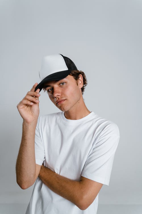 Man in White Crew Neck T-shirt Wearing White and Black Fitted Cap