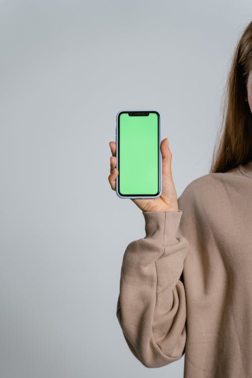 Woman in Gray Long Sleeve Shirt Holding Blue Iphone 5 C