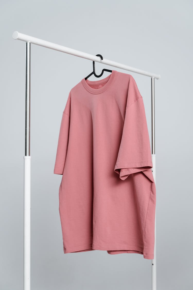 Pink Long Sleeve Shirt Hanging On White Metal Bar