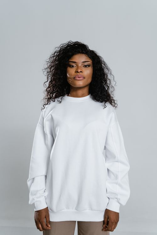 Free Elegant portrait of an African American woman wearing a white sweater in a studio setting. Stock Photo