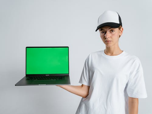 Woman Wearing Cap Holding a Laptop