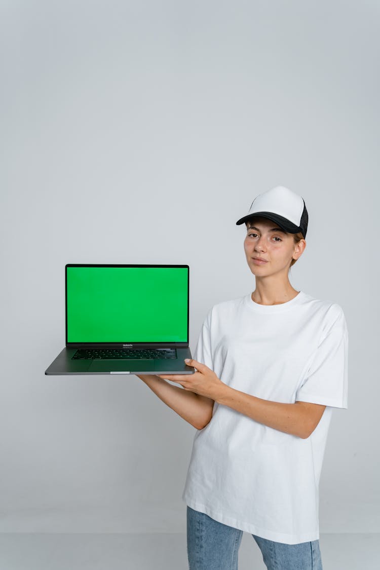 Woman In White Crew Neck T-shirt Holding Green Laptop Computer