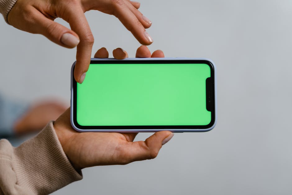 Noom vs WeightWatchers: Behavioral Tracking for Weight Loss (2026) Two hands using a smartphone with a green screen, ideal for mockups.