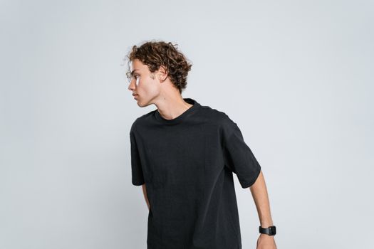 Casual portrait of a man in a black t-shirt standing against a light background.
