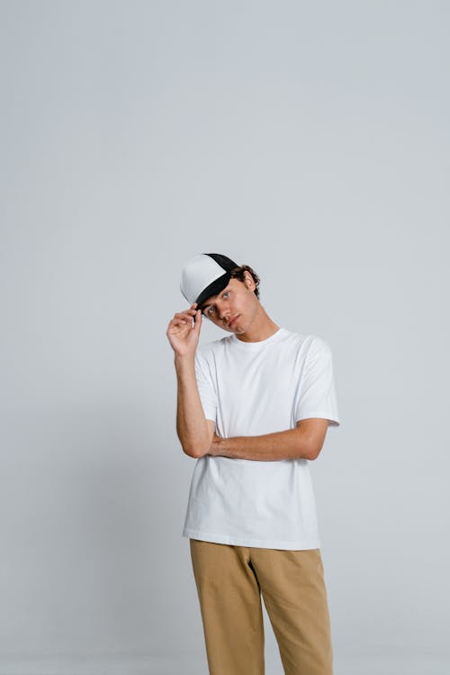 Безкоштовне стокове фото на тему «біла сорочка, вертикальні постріл, кепка»