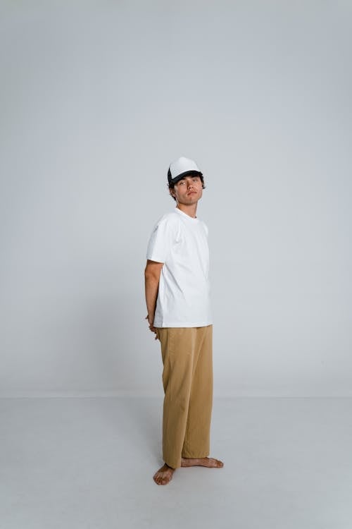 Man in White T-shirt and Brown Pants Wearing White Cap