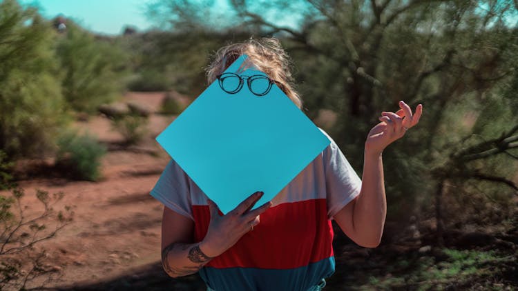 A Person Holding Blue Blank Paper