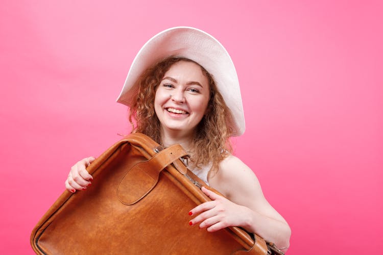 A Woman Holding A Leather Suitcase