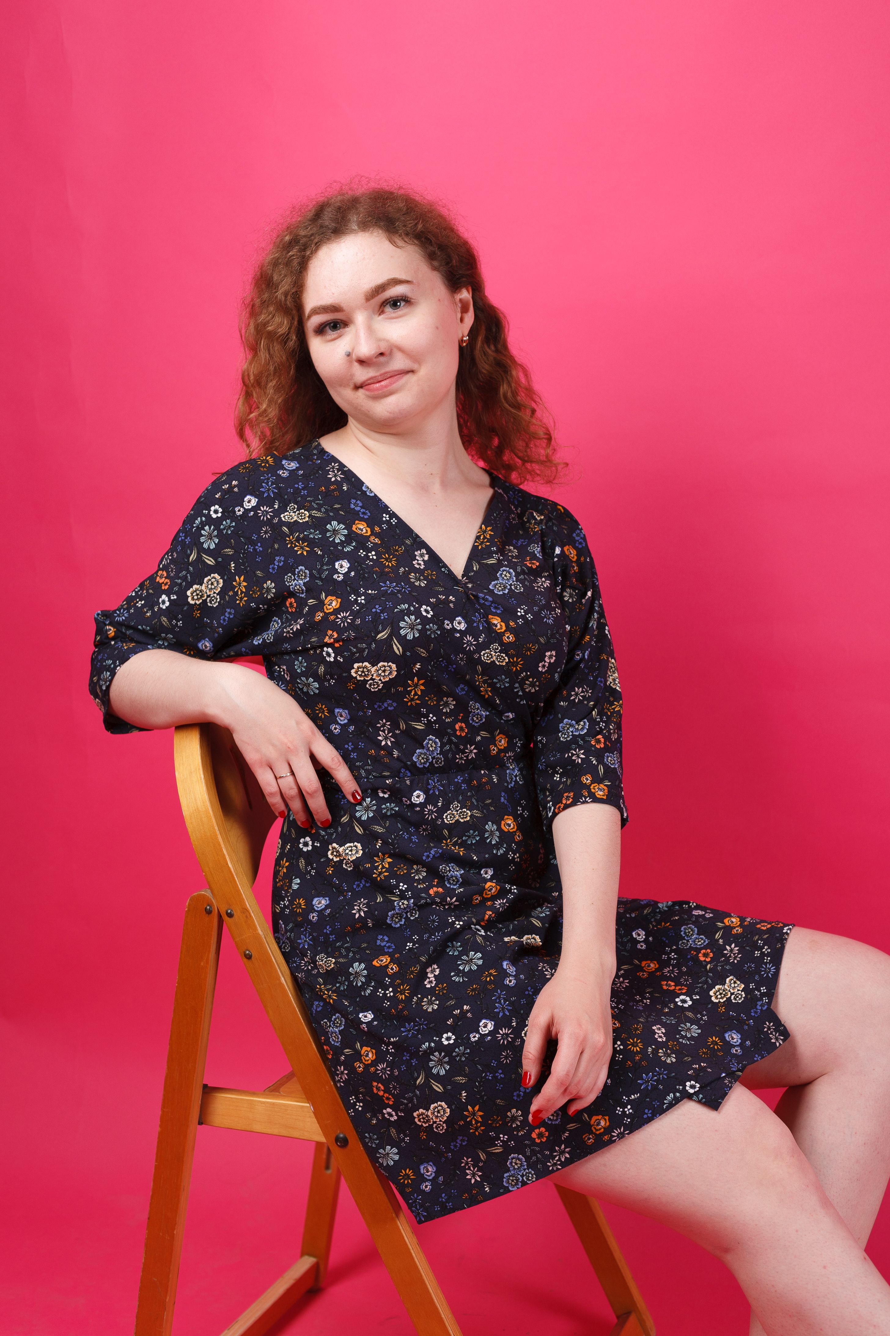 A Woman in a Floral Dress Sitting on a Wooden Chair · Free Stock Photo