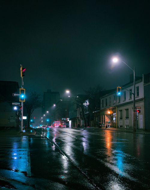 Free Illuminated urban street in Hamilton, ON at night with reflections on wet pavement. Stock Photo