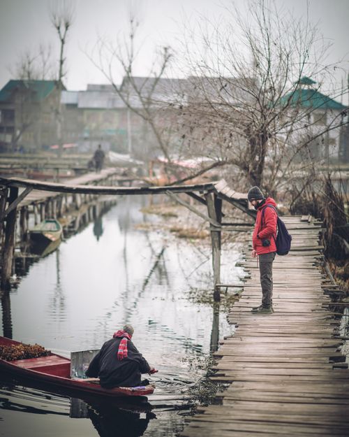 Free A peaceful moment on a wooden footbridge over a canal in Srinagar, Kashmir. Stock Photo