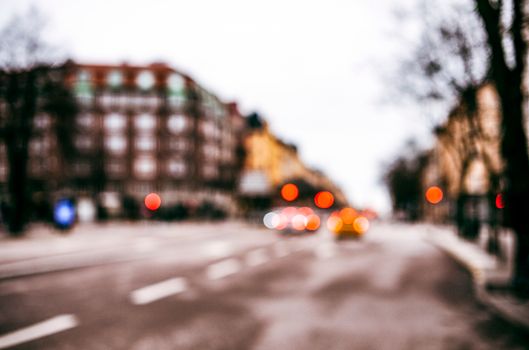 A blurred city street in Stockholm showcasing vibrant bokeh lights and urban architecture.