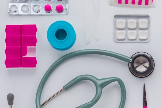 Top view of medical tools, pills, and equipment arranged on a white background, conveying healthcare essentials.