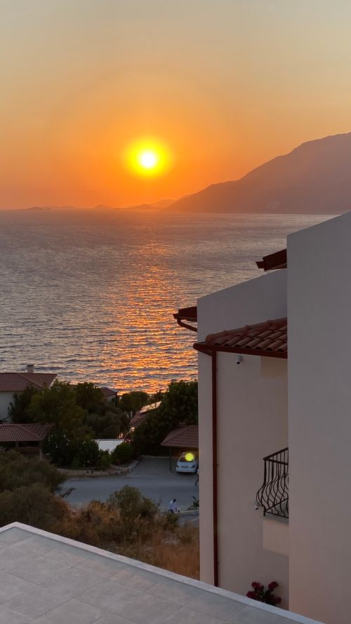Free Stunning sunset view over the sea and coastal homes in Kaş, Antalya, Turkey. Stock Photo
