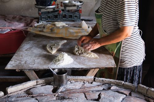 Free A person prepares homemade bread in a rustic kitchen setting, showcasing traditional baking techniques. Stock Photo