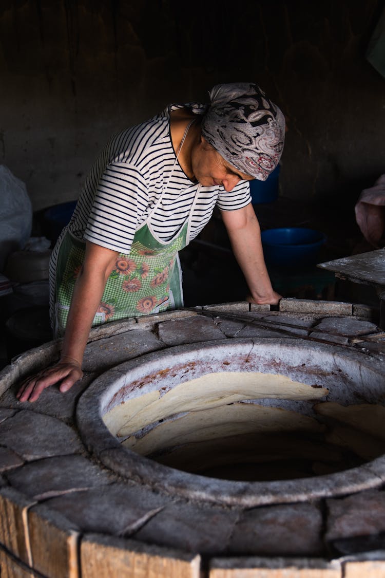 A Man Standing Beside Stone Oven