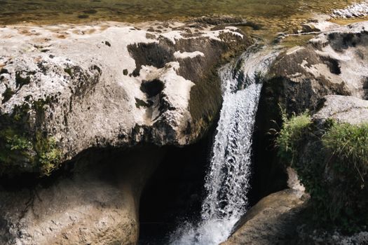 A refreshing waterfall cascading over rocks in a serene natural setting, ideal for nature photography.