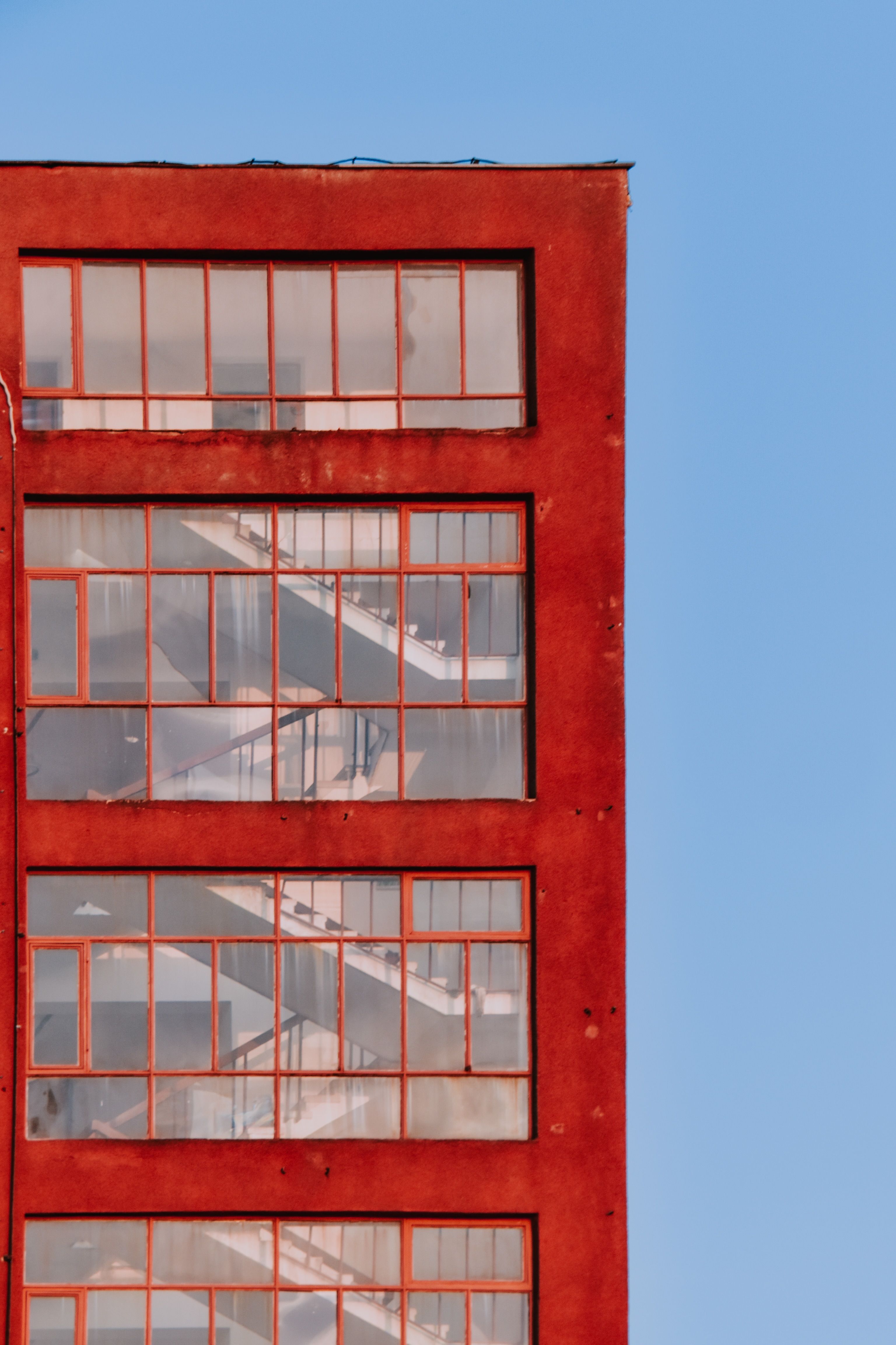 A Multi Storey Red Building with Glass Windows · Free Stock Photo