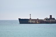 Black Ship on Sea Under White Sky