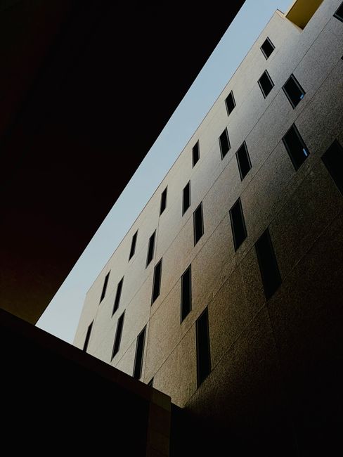 A dramatic low angle shot of a modern building at night with unique window patterns.