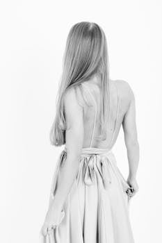 Graceful rear view of a woman in an elegant gown captured in black and white.