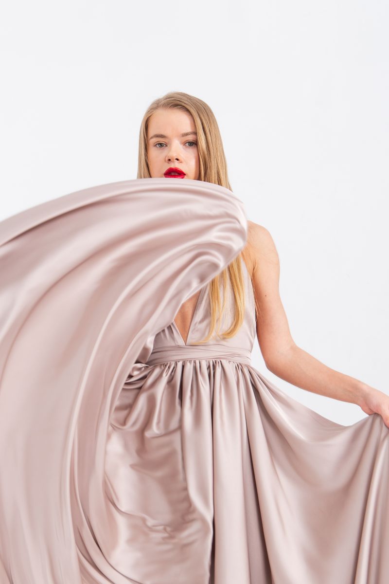 Woman in flowing satin gown against white backdrop, date night outfit