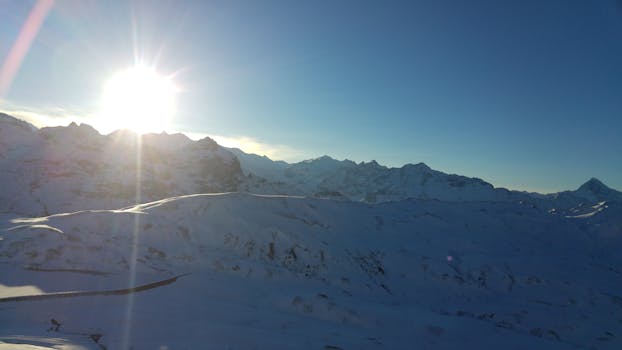 在瑞士克恩斯白雪皑皑的山脉上，美丽的日出高悬天际