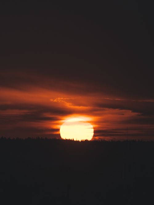 Free Stunning sunset with a dramatic sky, casting silhouettes on the horizon. Stock Photo