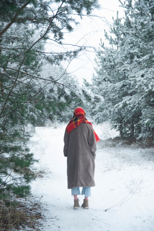 A Woman Standing on the Snow Covered Ground