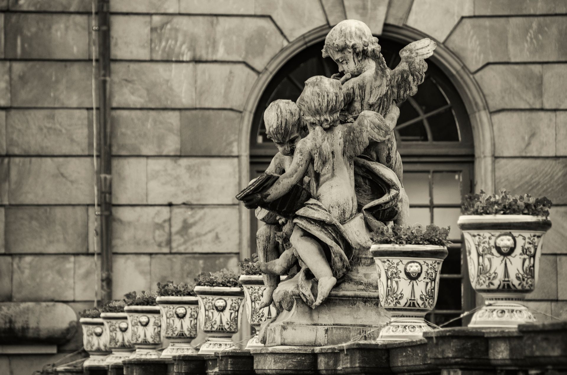 Elegant black and white photo of Baroque angel statues in a Stockholm courtyard.