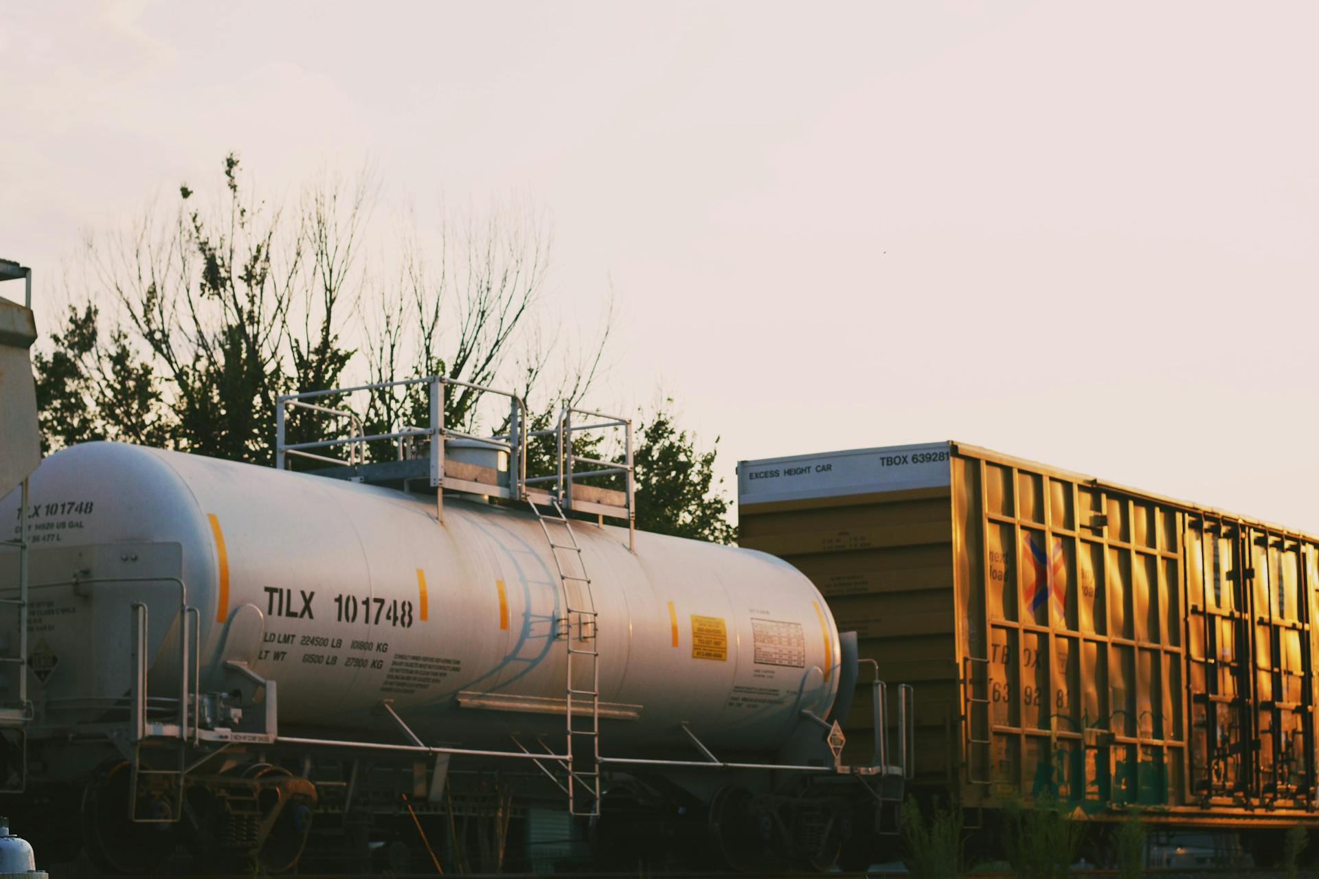 A freight train with cargo and tank containers in a sunset setting. Ideal for industrial themes.