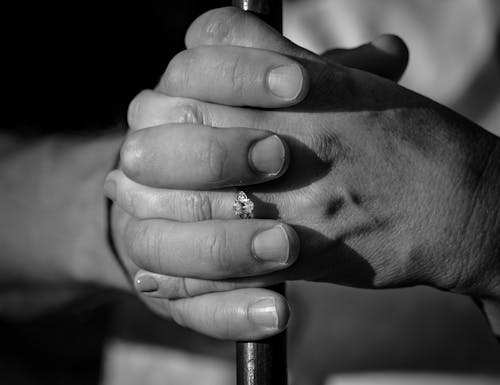 Grayscale Photo of a Person Holding a Pole