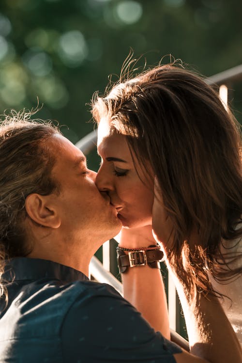 Free A Man Holding a Woman While Kissing Stock Photo