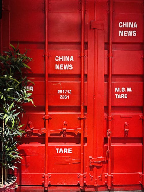 Door of Red Metal Container Beside Green Tree