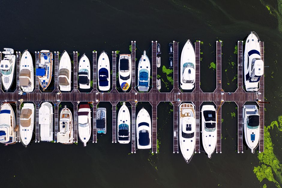 different types of boats (sailboat, motorboat, PWC) lined up at a dock - boat insurance near me different types of boats (sailboat, motorboat, PWC) lined up at a dock - boat insurance near me
