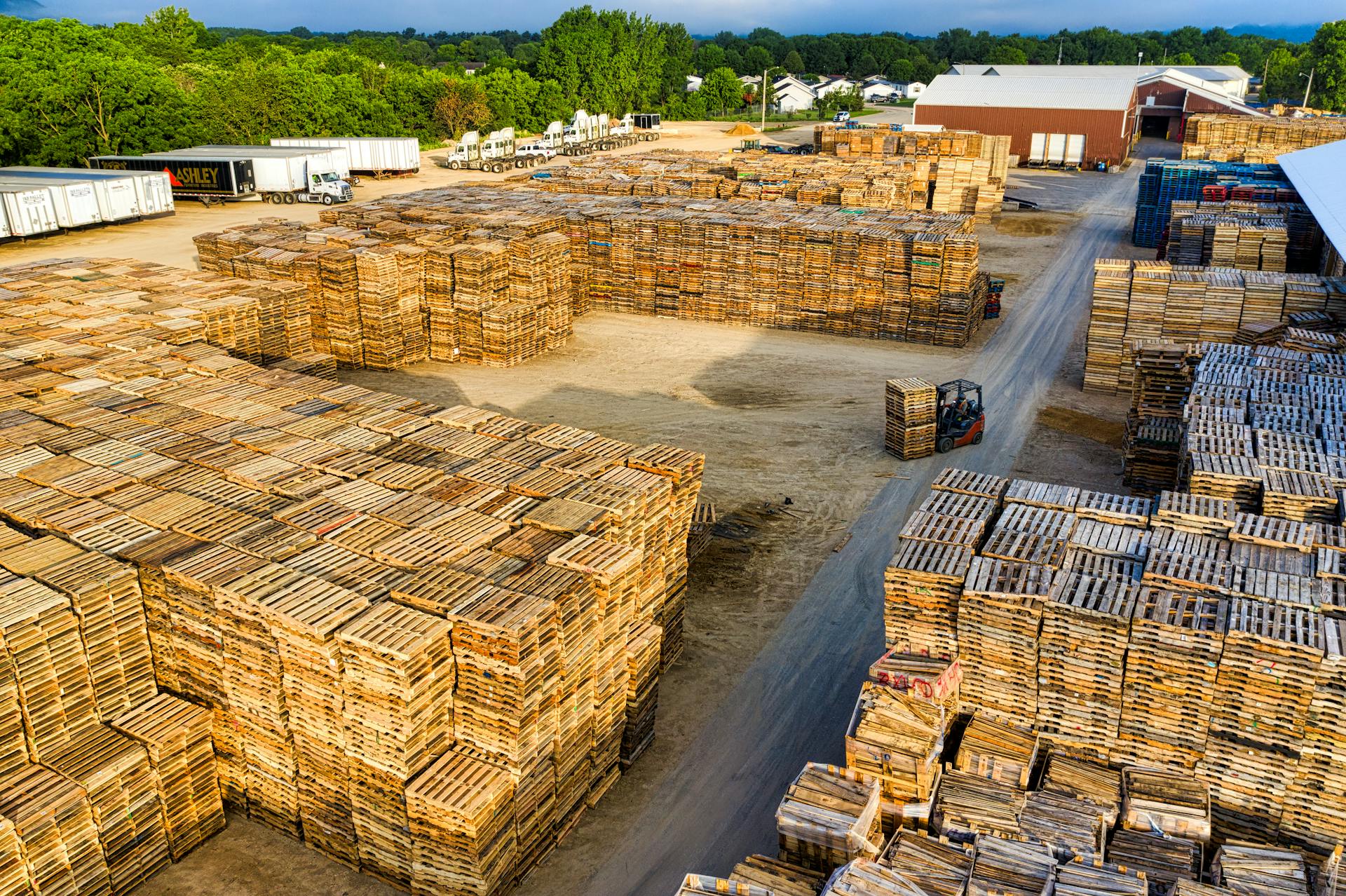 Aerial view showcasing large stacks of wooden pallets in an outdoor storage facility in Lake City, MN.