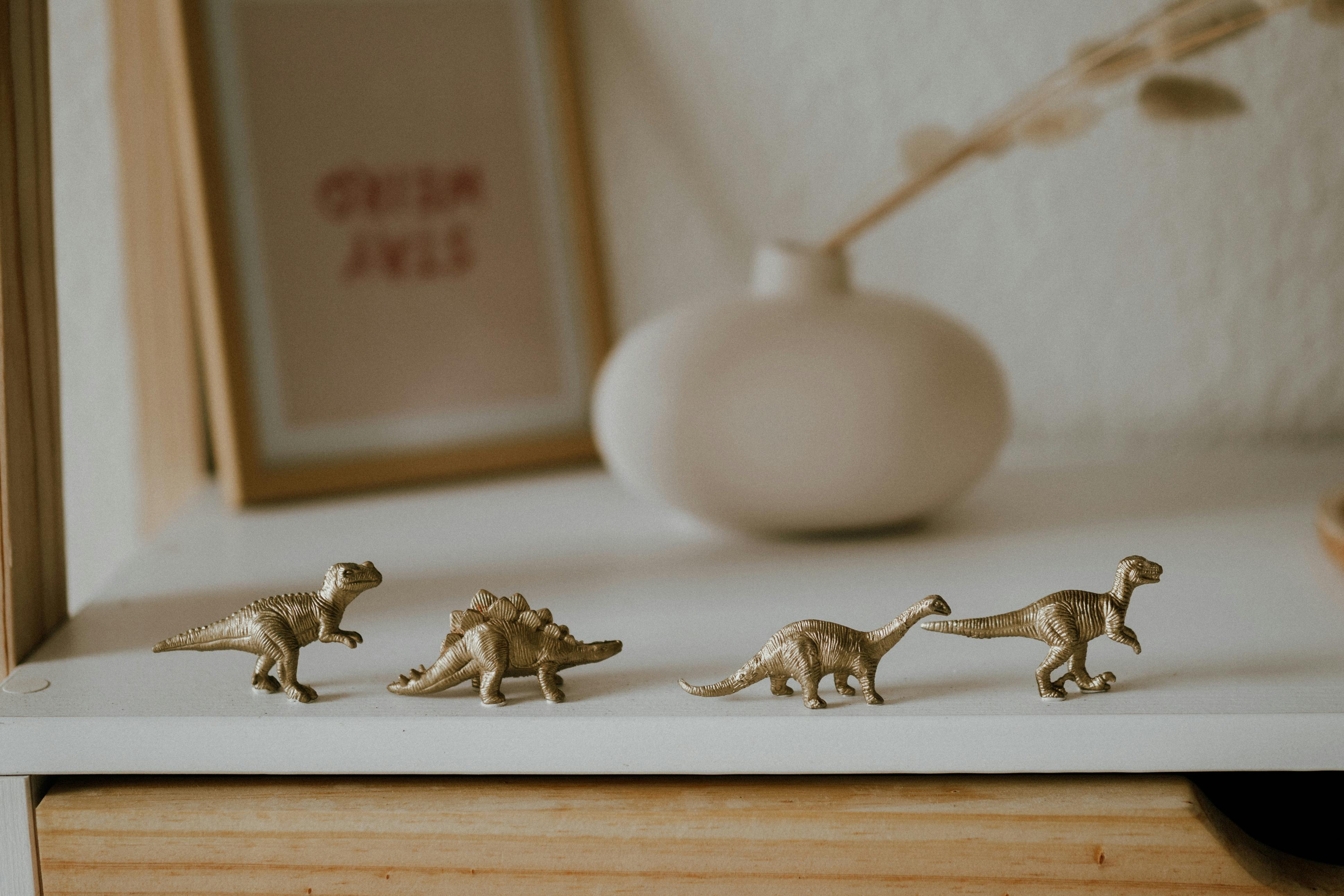 A stylish arrangement of toy dinosaurs on a minimalist shelf creates a whimsical indoor decor accent.