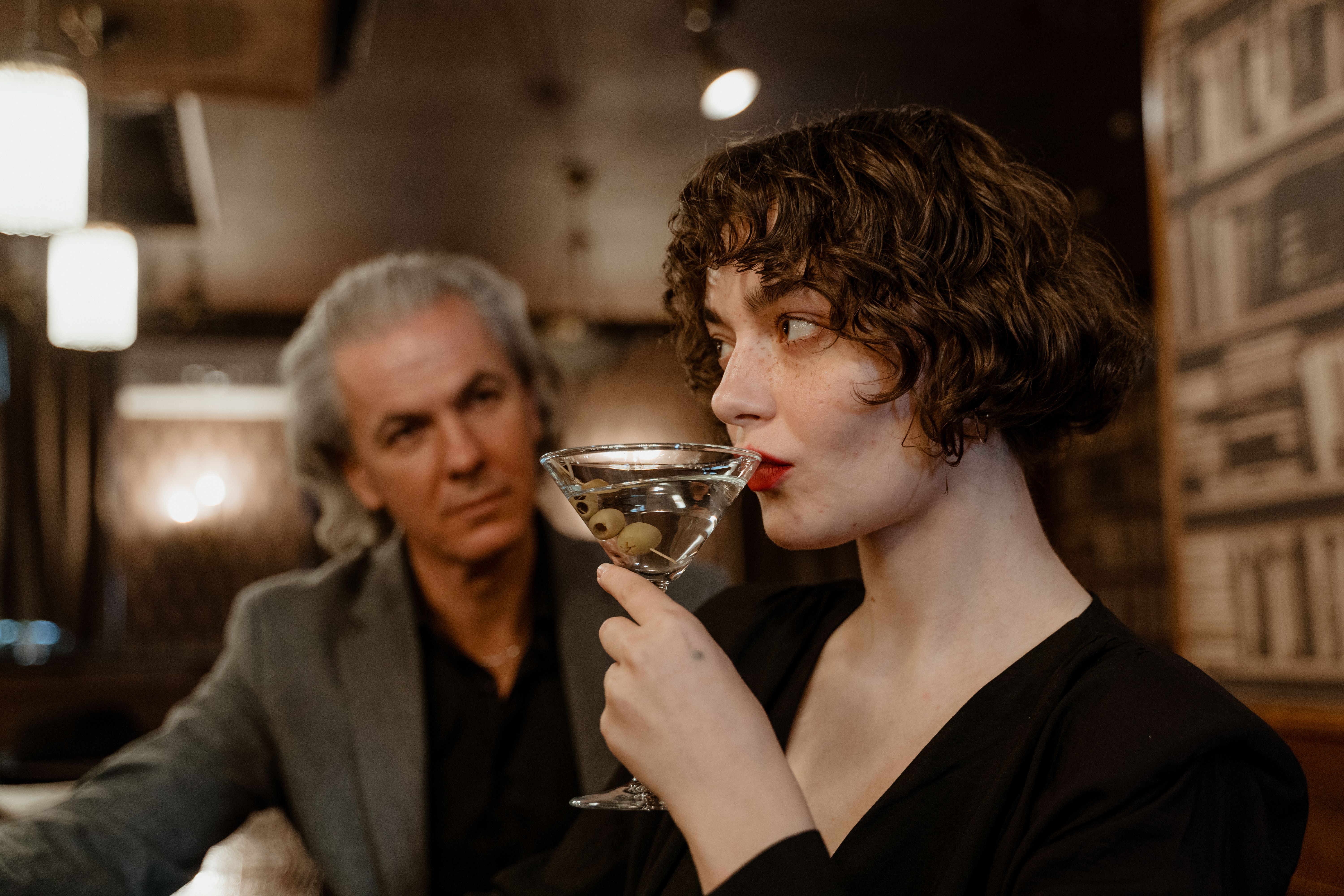 A mature couple enjoying cocktails in a stylish indoor setting, highlighting elegance and togetherness.