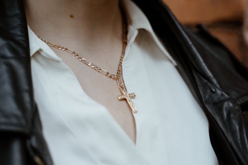 Free Close-Up Shot of a Person Wearing a Gold Cross Necklace Stock Photo