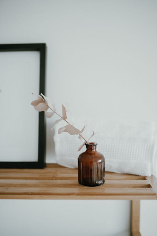 Brown Glass Bottle on Brown Wooden Table