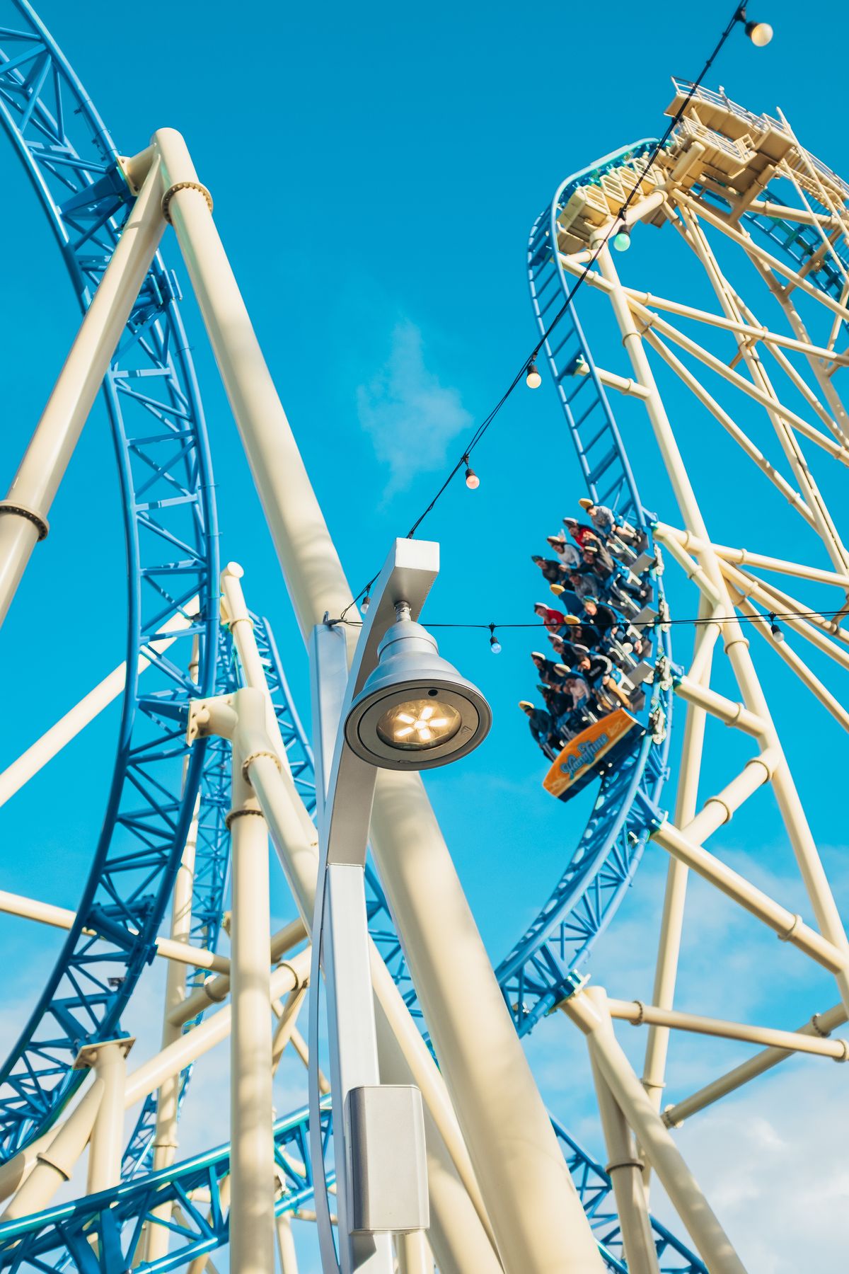 Riders on a roller coaster beneath a clear sky; illustrative stock image, not the Six Flags incident