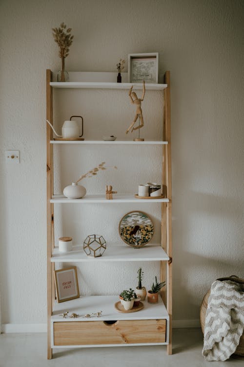 A Wooden Shelf With Figurines Beside a White Wall