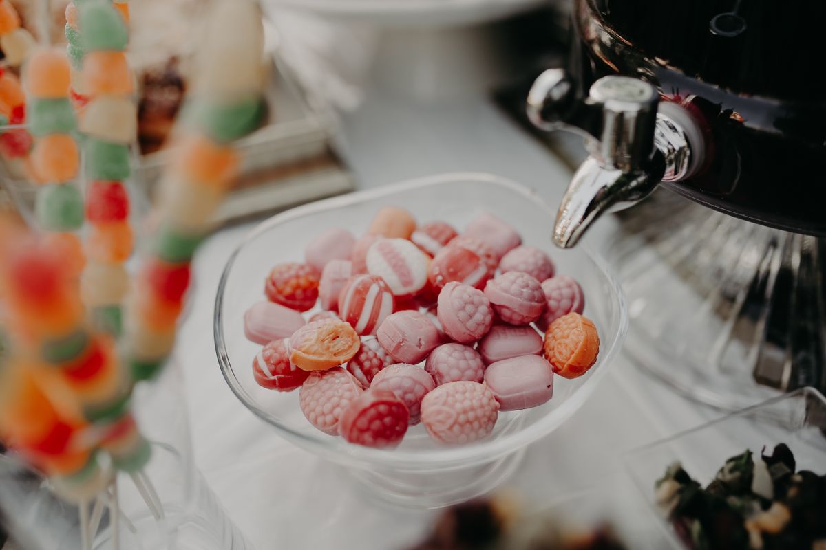 Vibrant close-up of assorted pink and orange candies in a glass dish, perfect for sweet-themed designs.