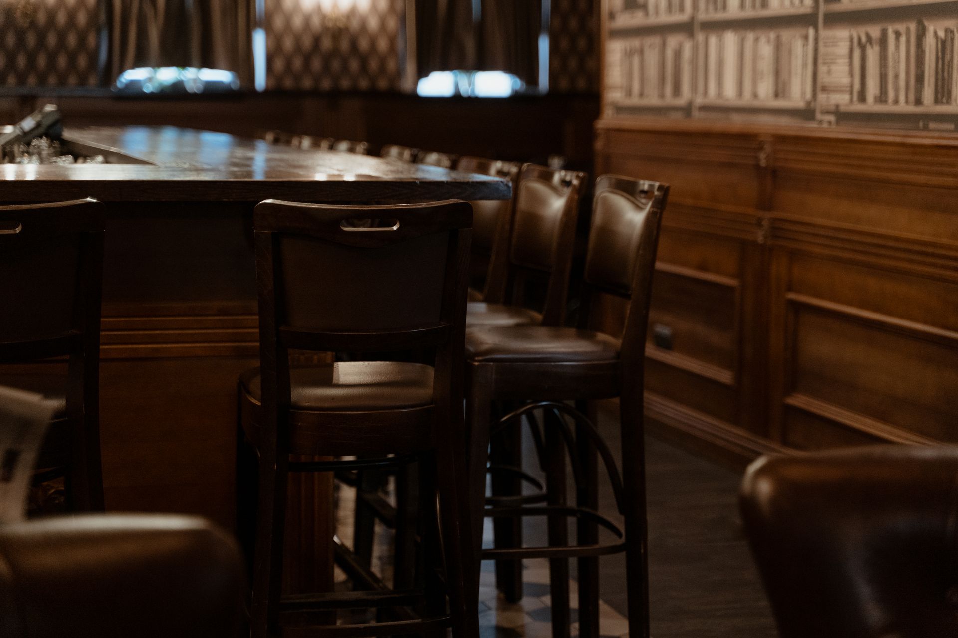 A warm and inviting vintage bar setting with wooden stools and counters.