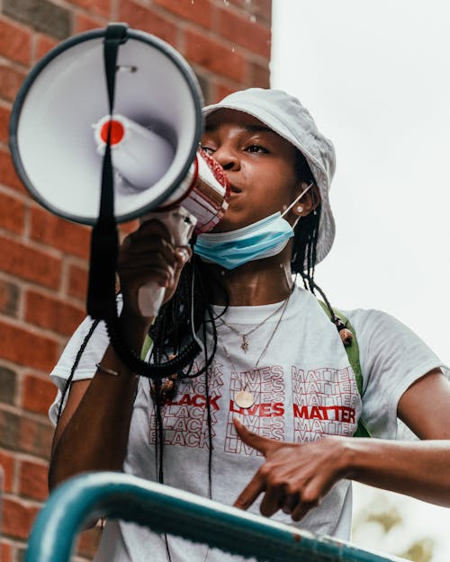 Free A Woman in White Crew Neck T-shirt Holding a Megaphone Stock Photo
