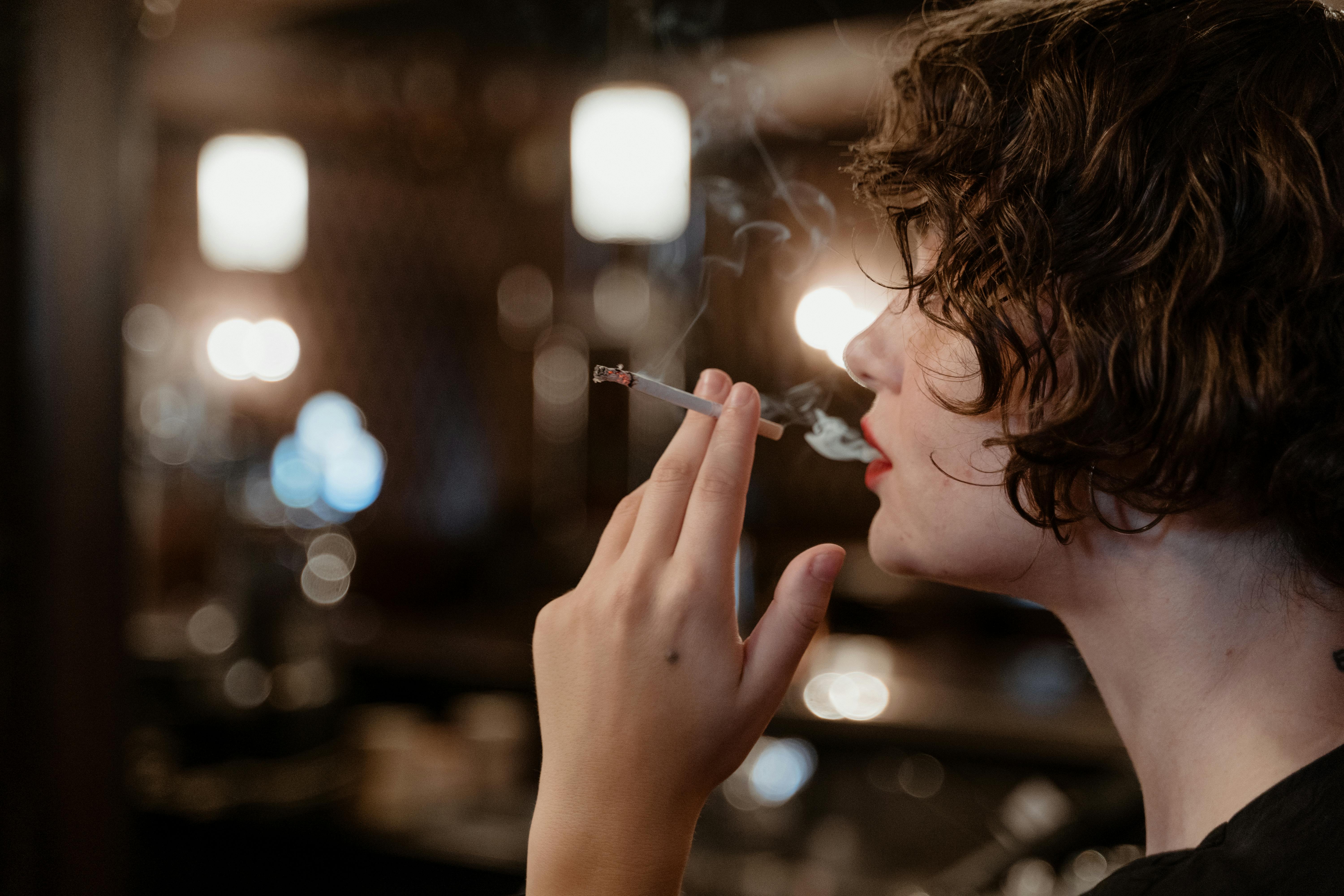 Young Woman with Short-Cut Blond Hair Smoking Cigarette · Free Stock Photo