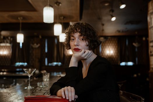 A fashionable woman with short hair in a classic bar setting, exuding elegance and style.